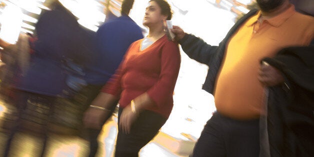 An overweight couple walking in Times Square after dark.