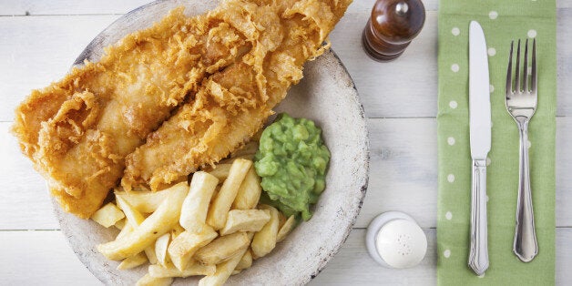 Traditional english food - Fish and chips with mushy peas on a white wooden background