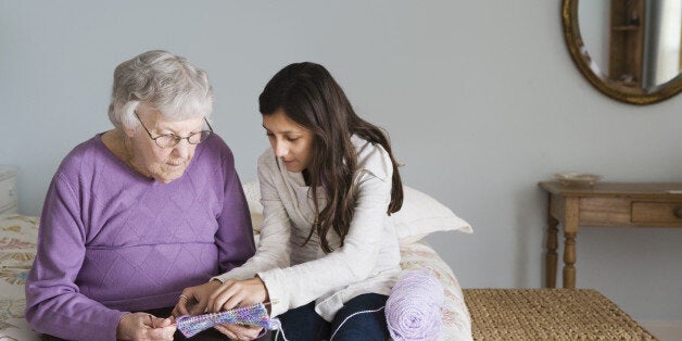 Grandmother and granddaughter knitting together