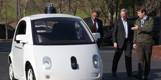 Google's Chris Urmson (R) shows a Google self-driving car to U.S. Transportation Secretary Anthony Foxx (L) and Google Chairman Eric Schmidt (C) at the Google headquarters on February 2, 2015 in Mountain View, California.