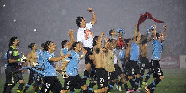 Uruguayan players celebrate after the end of the FIFA World Cup intercontinental play-offs 2nd Leg match against Jordan at the Estadio Centenario in Montevideo on November 20, 2013. Uruguay qualify for the World Cup. AFP PHOTO / MIGUEL ROJO (Photo credit should read MIGUEL ROJO/AFP/Getty Images)