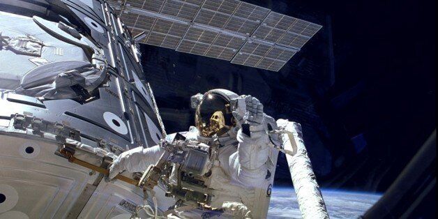 Astronaut James H. Newman waves during a spacewalk preparing for release of the first combined elements of the International Space Station