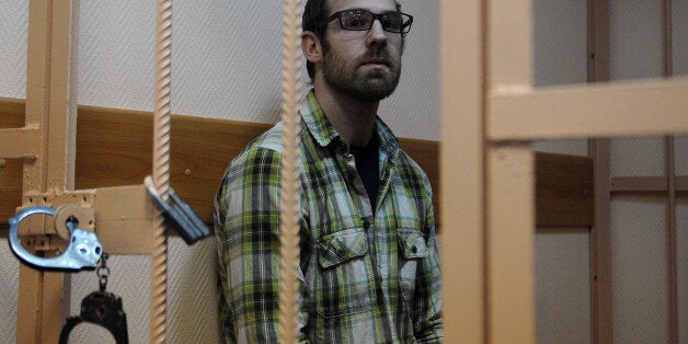 Freelance videographer Kieron Bryan from the United Kingdom, one of the 'Arctic 30,' sits in a defendant cage in a court in Russia's second city of Saint Petersburg, on November 18, 2013. Russia put last week the so called 'Arctic 30' in prisons in Saint Petersburg, after moving them from Murmansk where they have spent weeks in jail after their ship Arctic Sunrise was seized by Russian security forces in a commando-style operation in Arctic waters following a protest at a Gazprom oil rig. AFP