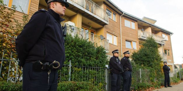 Police officers stand outside flats in Brixton, south London, as police are conducting house-to-house inquires in the area where three women were allegedly held as slaves for at least 30 years were rescued.