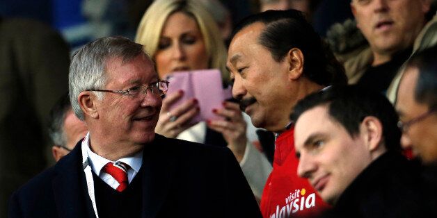Manchester United's Scottish former manager Alex Ferguson (L) stands with Cardiff City's Malaysian majority shareholder Vincent Tan (R) ahead of the English Premier League football match between Cardiff City and Manchester United at Cardiff City Stadium in Cardiff, south Wales on November 24, 2013. AFP PHOTO/ADRIAN DENNIS RESTRICTED TO EDITORIAL USE. No use with unauthorized audio, video, data, fixture lists, club/league logos or live services. Online in-match use limited to 45 images, no video