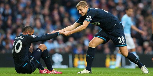 MANCHESTER, ENGLAND - NOVEMBER 24: Michael Dawson of Tottenham Hotspur helps Sandro to his feet during the Barclays Premier League match between Manchester City and Tottenham Hotspur at Etihad Stadium on November 24, 2013 in Manchester, England. (Photo by Alex Livesey/Getty Images)