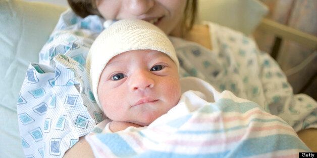 Newborn baby boy in mother's arms