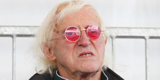 Sir Jimmy Savile watches as Britain's Queen Elizabeth II names Cunard's newest cruise ship, the Queen Elizabeth in Southampton.