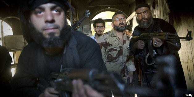 Syrian rebels take position in a house during clashes with regime forces in the old city of Aleppo