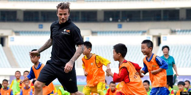 NANJING, CHINA - JUNE 18: (CHINA OUT) David Beckham plays football with children at at Nanjing Olympic Sports Center on June 18, 2013 in Nanjing, Jiangsu Province of China. (Photo by ChinaFotoPress/ChinaFotoPress via Getty Images)