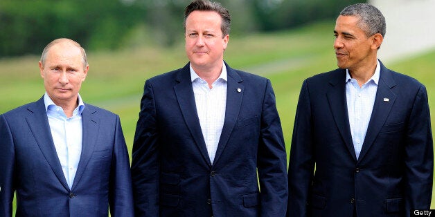 Britain's Prime Minister David Cameron (C) stands planked by Russia's President Vladimir Putin (L) and US President Barack Obama (R) with their G8 and EU colleagues on the podium for the family photograph on the second day of the G8 summit at the Lough Erne resort near Enniskillen in Northern Ireland on June 18, 2013. Russia and the US agreed at the G8 summit to push for Syria peace talks, but Presidents Vladimir Putin and Barack Obama made clear their deep differences over the conflict. AFP PH