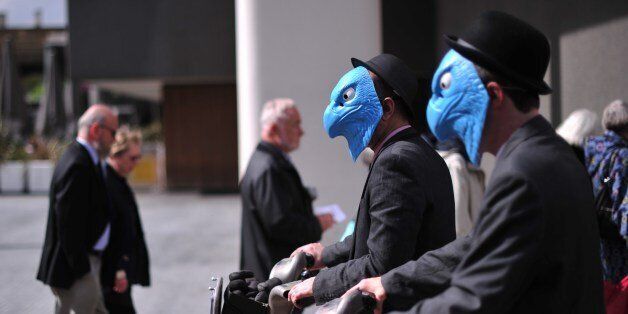 Protesters wearing masks in a satirical rendering of the eagle emblem of Barclay's Bank stage a demonstration near the venue of the Bank's annual general meeting in London on April 24, 2014. Barclays announced, amid rising anger over its plans to pay higher bonuses, and as shareholders gathered for the bank's annual general meeting, that its first quarter profits will show a 'small reduction' from a year earlier after a fall in revenues at part of its investment bank. AFP PHOTO / CARL COURT