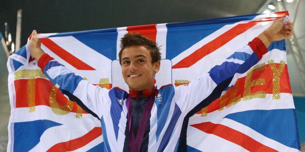 LONDON, ENGLAND - AUGUST 11: Bronze medallist Tom Daley of Great Britain poses with the national flag after the medal ceremony for the Men's 10m Platform Diving Final on Day 15 of the London 2012 Olympic Games at the Aquatics Centre on August 11, 2012 in London, England. (Photo by Clive Rose/Getty Images)