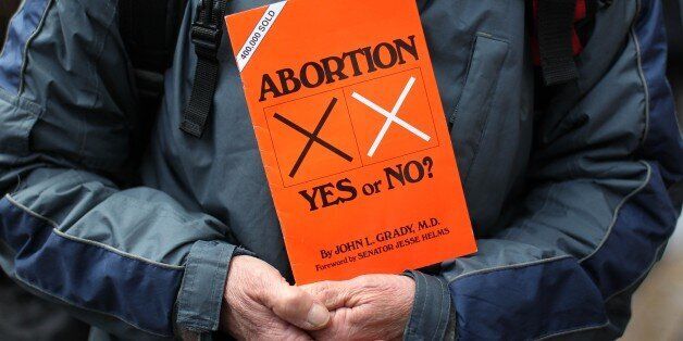 A anti abortion protestors holds up placards outside the Marie Stopes clinic, the first private clinic to offer abortions to women in Belfast, Northern Ireland on October 18, 2012. Dozens of pro-life campaigners protested outside the first abortion clinic in Northern Ireland as it opened to the public. Around 50 protesters brandishing placards saying 'Life is precious' and showing photographs of foetuses gathered outside the privately run clinic in an anonymous building in Belfast. AFP PHOTO/ Pe