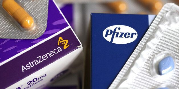 The Pfizer Inc. company logo, right, and the AstraZeneca Plc company logo, are seen on boxes of pharmaceutical products produced by the drug makers in this arranged photograph taken in London, U.K., on Friday, May 2, 2014. AstraZeneca Plc rejected Pfizer Inc.'s sweetened takeover proposal, saying the 63.1 billion-pound ($106.5 billion) offer fails to recognize the value of the promising experimental medicines under development by the U.K.'s second-biggest drugmaker. Photographer: Chris Ratcliffe