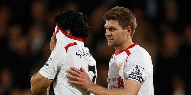 Liverpool's English midfielder Steven Gerrard (R) shepherds Liverpool's Uruguayan striker Luis Suarez (L) from the field as he reacts at the end of the English Premier League football match between Crystal Palace and Liverpool at Selhurst Park in south London on May 5, 2014. The match ended in a 3-3 draw. AFP PHOTO / ADRIAN DENNIS RESTRICTED TO EDITORIAL USE. No use with unauthorized audio, video, data, fixture lists, club/league logos or live services. Online in-match use limited to 45 images, no video emulation. No use in betting, games or single club/league/player publications. (Photo credit should read ADRIAN DENNIS/AFP/Getty Images)