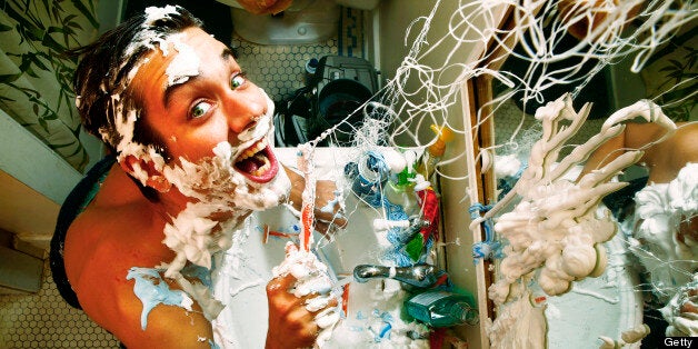 Man making a mess brushing his teeth. He even leaves the water running. I hope he's getting ready for something important.