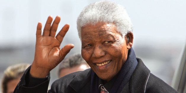 Former South African President Nelson Mandela salutes upon his arrival at Madrid's Barajas airport 21 May 2004 to attend the wedding of Spanish Crown Prince Felipe of Bourbon and former TVE journalist Letizia Ortiz. AFP PHOTO Javier SORIANO (Photo credit should read JAVIER SORIANO/AFP/Getty Images)
