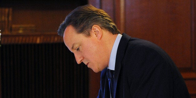 Prime Minister David Cameron signs the book of condolence at the South African Embassy in central London following the announcement of the death of the former South African leader Nelson Mandela who has died at the age of 95.