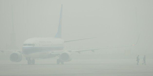 An aircraft is barely visible through thick smog on the tarmac of Hongqiao airport in Shanghai as severe pollution blankets the city on December 6, 2013. The cities most harmful PM2.5 density soared to 468 micrograms per cubic metre by midnight more than 10 times the level deemed safe by the World Health Organization state media said. AFP PHOTO/Peter PARKS (Photo credit should read PETER PARKS/AFP/Getty Images)