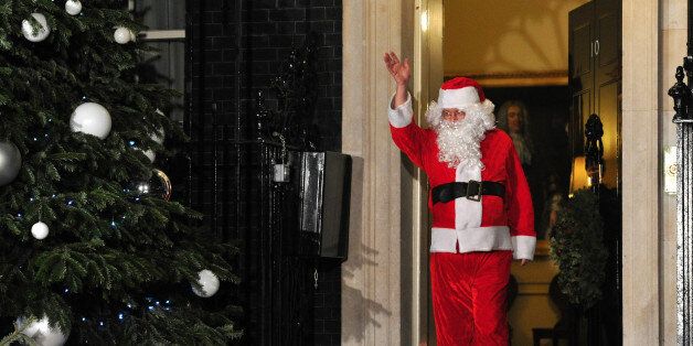 A man dressed as Father Christmas waves as he leaves the annual Downing Street children's christmas Party at 10 Downing Street in central London on December 17, 2012. AFP PHOTO / CARL COURT (Photo credit should read CARL COURT/AFP/Getty Images)