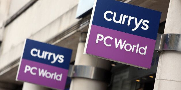 Signs hang above the entrance to a Currys PC World store, operated by Dixons Retail Plc, in London, U.K., on Thursday, March 20, 2014. Dixons Retail, the largest U.K. consumer-electronics retailer, said it's in talks to merge with Carphone Warehouse Group Plc, bringing together companies with combined revenue of about 12 billion pounds ($20 billion). Photographer: Chris Ratcliffe/Bloomberg via Getty Images