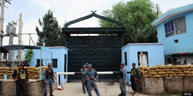 Afghan policemen stand guard at the gate of the main prison in Herat