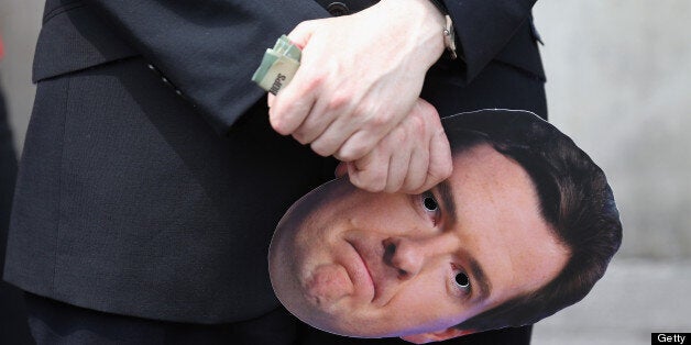 LONDON, ENGLAND - JUNE 27: A member of the public and commercial services union holds a Chancellor of the Exchequer George Osborne face mask at a demonstration on Whitehall on June 27, 2013 in London, England. The union members were expressing their opposition to the 11.5 billion GBP cut to public spending outlined by the Chancellor of the Exchequer George Osborne in the House of Commons yesterday. (Photo by Oli Scarff/Getty Images)