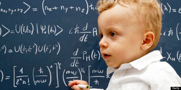 Very young professor writing equations on a blackboard