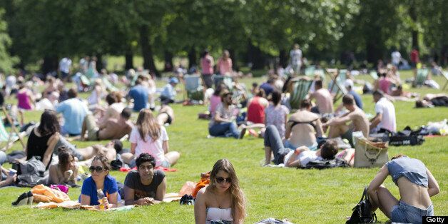 People sunbathe in the summer heat in a park in central London on June 30, 2013. AFP PHOTO / JUSTIN TALLIS (Photo credit should read JUSTIN TALLIS/AFP/Getty Images)