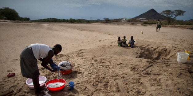 A Turkana woman washes clothes using water she scooped from a dry river bed in Lodwar (Turkana region) on March 13, 2014. A first downpour relieved pastoralists in the drought stricken Kenyan Turakana region after a twelve month span that pushed livestocks and communities to the brink of another looming humanitarian crisis.AFP PHOTO/ MARCO LONGARI (Photo credit should read MARCO LONGARI/AFP/Getty Images)