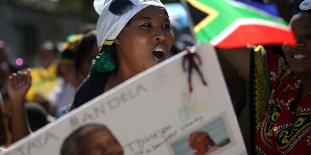 JOHANNESBURG, SOUTH AFRICA - DECEMBER 15: People sing and dance as they gather outside the home of former South African President Nelson Mandela on the day that the iconic leader was laid to rest in his home village on December 15, 2013 in Johannesburg, South Africa. Mr. Mandela passed away on the evening of December 5, 2013 at his home in Houghton at the age of 95. Mandela became South Africa's first black president in 1994 after spending 27 years in jail for his activism against apartheid in