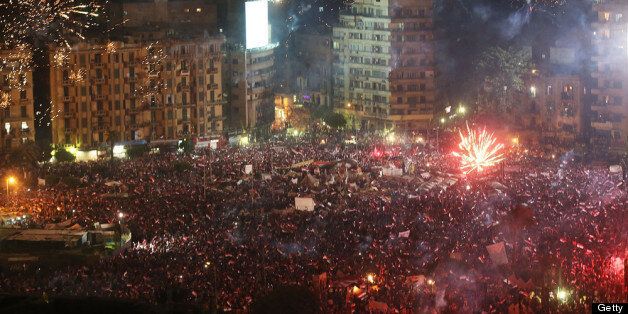 CAIRO, EGYPT - JULY 03: Fireworks and shouts of joy emanate from Tahrir Square after a broadcast by the head of the Egyptian military confirming that they will temporarily be taking over from the country's first democratically elected president Mohammed Morsi on July 3, 2013 in Cairo, Egypt. As unrest spreads throughout the country, at least 23 people were killed in Cairo on Tuesday and over 200 others were injured. It has been reported that the military has taken over the state television. (Ph