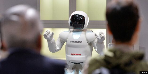 Honda Motor's humanoid robot Asimo interacts with visitors at the National Museum of Emerging Science and Innovation in Tokyo on July 3, 2013. Honda developed an autonomous behavior control technology, which enables Asimo to make decisions required to behave in concert with the movements of the surrounding people without being controlled by an operator. AFP PHOTO / Yoshikazu TSUNO (Photo credit should read YOSHIKAZU TSUNO/AFP/Getty Images)