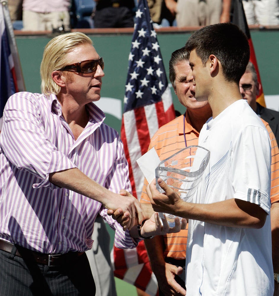 Novak Djokovic (R) of Serbia recieves th