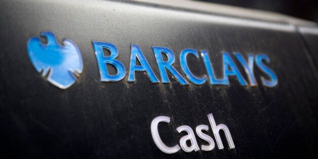 A Barclays logo sits above the word 'Cash' on an automated teller machine (ATM) outside a Barclays Plc bank branch in London, U.K., on Wednesday, May 7, 2014. Barclays will cut 7,000 jobs at its investment bank, bringing the total number of jobs to be cut across the firm by 2016 to 19,000, including the 12,000 the lender announced in February it would cut this year, Barclays said in a statement. Photographer: Simon Dawson/Bloomberg via Getty Images