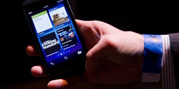 A member of the RIM team poses with one of the new touchscreen Z10 Blackberry devices in central London at one of eight simultaneous worldwide events for the launch of the BB10 operating system on January 30, 2013. Seen by some as the company's last chance to survive, Blackberry hope that the combination of a more user-friendly software interface with fresh touch-screen devices will bring the company back into shape in the face of strong market control by Apple and Samsung. AFP PHOTO/Leon Neal