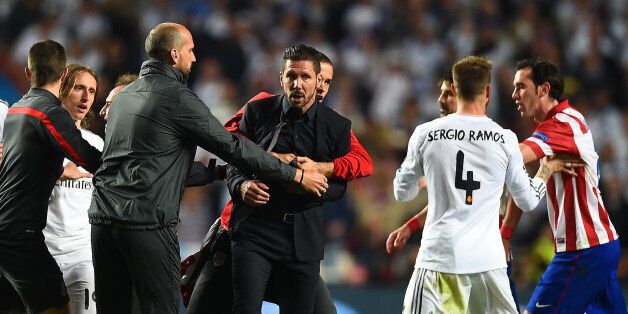 LISBON, PORTUGAL - MAY 24: Diego Simeone, Coach of Club Atletico de Madrid is restrained as he clashes with Sergio Ramos of Real Madrid during the UEFA Champions League Final between Real Madrid and Atletico de Madrid at Estadio da Luz on May 24, 2014 in Lisbon, Portugal. (Photo by Laurence Griffiths/Getty Images)