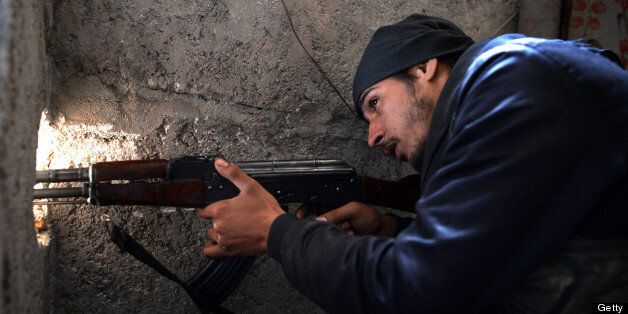 A Syrian rebel fighter points his weapon towards the positions of Syrian government forces in the Saladin district of the northern Syrian city of Aleppo on April 8, 2013. AFP PHOTO / DIMITAR DILKOFF (Photo credit should read DIMITAR DILKOFF/AFP/Getty Images)