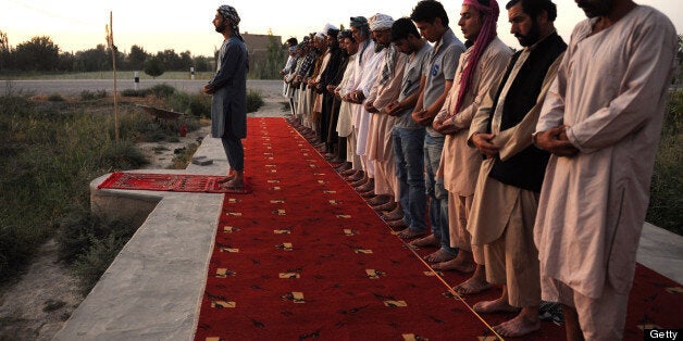 Afghan men pray in an open area during the holy month of Ramadan on the outskirts of Mazar-i Sharif on July 12, 2013. Throughout the month, devout Muslims must abstain from food and drink from dawn until sunset when they break the fast with the Iftar meal. AFP PHOTO / Farshad USYAN (Photo credit should read FARSHAD USYAN/AFP/Getty Images)