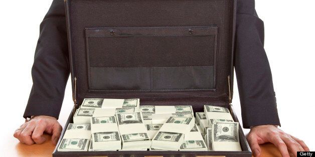 Business man standing next to open briefcase with money ,bribe concept
