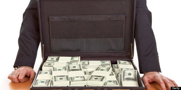 Business man standing next to open briefcase with money ,bribe concept