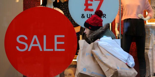 A shop on Market Street in Manchester advertises its sale, as shoppers buy last minute items before Christmas Day.