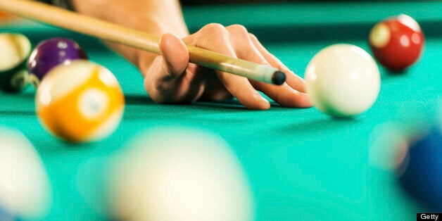 Unrecognizable person playing billiards.