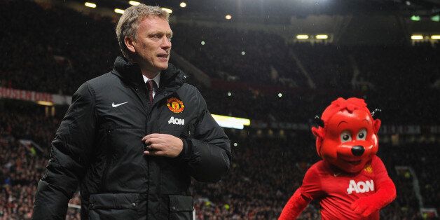 MANCHESTER, ENGLAND - JANUARY 01: Manchester United Manager David Moyes walks with mascot Fred the Red prior to the Barclays Premier League match between Manchester United and Tottenham Hotspur at Old Trafford on January 1, 2014 in Manchester, England. (Photo by Michael Regan/Getty Images)