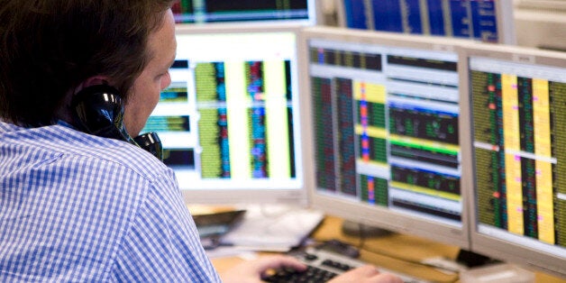 UNITED KINGDOM - MARCH 03: A stockbroker talks on the telephone while working on his computer at Shore Capital Markets in London, U.K., on Tuesday, March 3, 2009. U.K. stocks retreated for a third day, sending the benchmark FTSE 100 Index to its lowest since 2003, amid concern banks may have to raise more capital. (Photo by Chris Ratcliffe/Bloomberg via Getty Images)