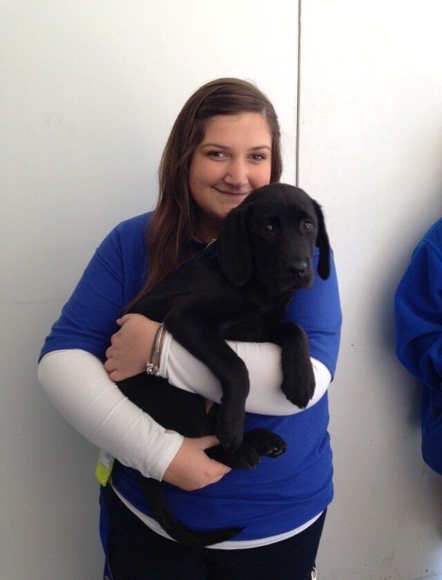 Charlotte with a guide dog pup while volunteering