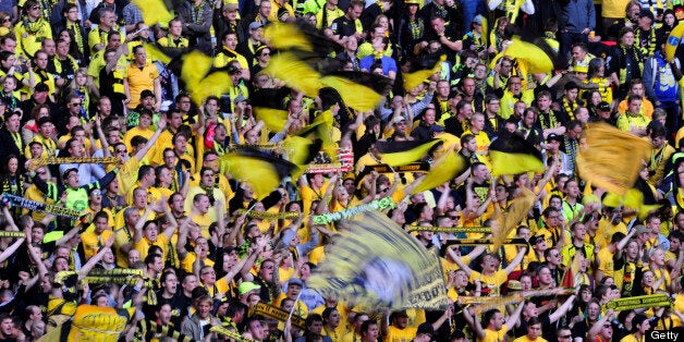 Borussia Dortmund supporters singing in the crowd ahead of the UEFA Champions League final football match between Borussia Dortmund and Bayern Munich at Wembley Stadium in London on May 25, 2013 AFP PHOTO / GLYN KIRK (Photo credit should read GLYN KIRK/AFP/Getty Images)