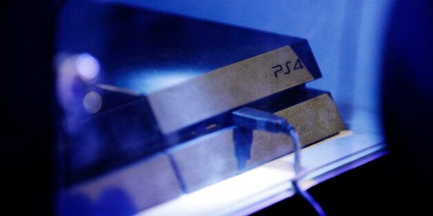 A logo sits above a USB cable attached to a PlayStation 4 (PS4) games console, manufactured by Sony Corp., during the Eurogamer Expo 2013 in London, U.K., on Saturday, Sept. 28, 2013. Last year, the number of consoles in consumers' homes, including the Xbox 360, PlayStation 3 and Wii U, stood at 238 million, according to IHS Screen Digest. Photographer: Matthew Lloyd/Bloomberg via Getty Images