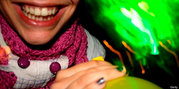 Detail of someone smiling and holding a laughing gas balloon. (Photo by Universal Images Group via Getty Images)